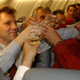 Men cheersing wine glasses on crowded plane
